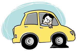 Une voiture jaune de profil. Les deux roues de côté apparaissent et celle de devant semble crevée. Le conducteur apparait par la fenêtre avec une expression mécontente ou ennuyée.