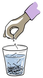 Une main au-dessus d’un verre d’eau. Cela suggère que la main jette des clous dans le verre, plusieurs se trouvent déjà au fond du verre.